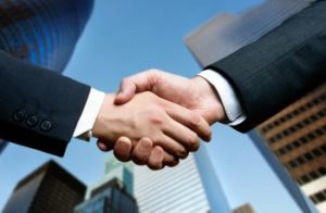 Stretta di mano davanti a edifici alti