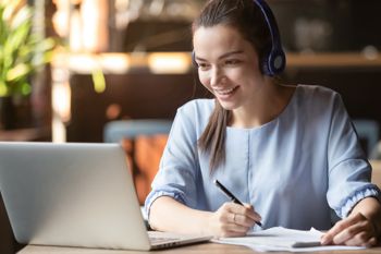 Donna che segue un corso di formazione su un laptop alla sua scrivania